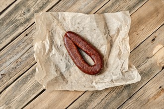 Top view of smoked dried deer sausage on wrapping paper