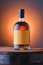 Blended malt scotch whisky on top of the barrel over blue and orange gradient background