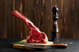 Raw prime ribeye steak on wooden cutting board
