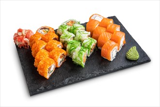 Big set of rolls with wasabi and pickled ginger on stone serving board isolated on white