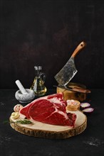 Raw top round roast beef steak on wooden cutting board