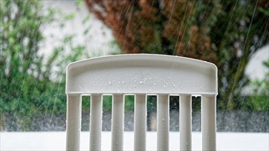 Back of a garden chair in heavy rain