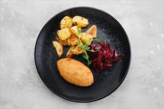 Kiev or pozharskaya cutlet served with fried potato and beet on a plate