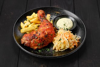 Baked chicken leg with american fries and pickled cabbage on a plate
