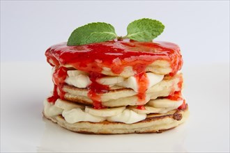 Pile of flapjacks with strawberry jam and banana
