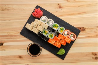 Big set of rolls with traditional garnish on wooden table