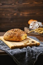 Fresh oats bread with sunflower seeds and sesame on wooden table