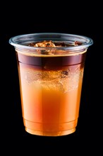 Espresso tonic with sea buckthorn syrup in take away cup isolated on black background