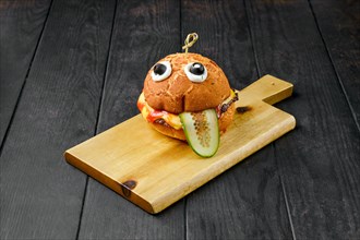 Hamburger with beef for children on wooden board