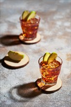 Apple juice whiskey cocktail under hard sunlight