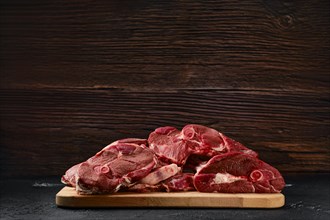 Assortment of raw fresh lamb meat on wooden tray