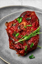 Closeup view of ossobuco on a plate. Slice of shank baked with wine sauce