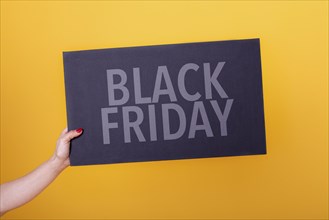 Female hand holding a black friday poster