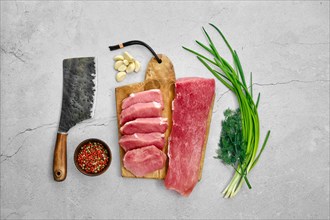 Raw fresh pork fillet and chops on concrete background