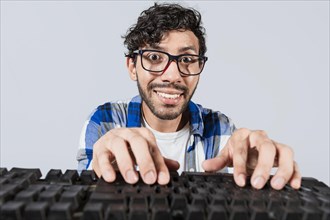 Portrait of nerdy man in front of keyboard