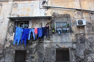 Laundry drying on the line on the wall of a morbid apartment building in the old town of Naples