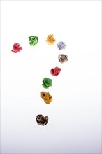 Colorful crumpled paper form a question mark on a white background