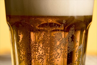 Closeup glass cold beer with golden bubble