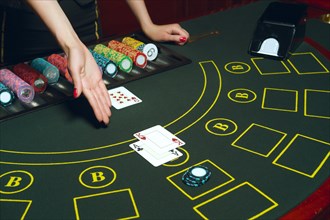Casino poker table with chips and cards. Winning combination. Hand of Croupier open cards