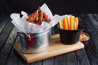Snack for beer. Spicy chicken wings with fresh carrot and celery and sauce