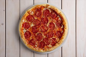 Classic pizza pepperoni on wooden background
