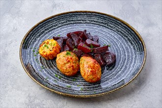 Plate with fried pork cutlet with roasted beetroot slices and grilled maize