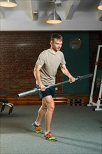 Triathlon sportsman rowing with barbell. Fitness workout