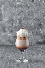 Coffee cocktail with whipped cream on shabby grey background