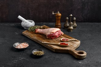 Raw turkey drumstick with skin on wooden board