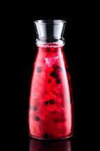 Cold sangria with forrest berries in a jar isolated on black background