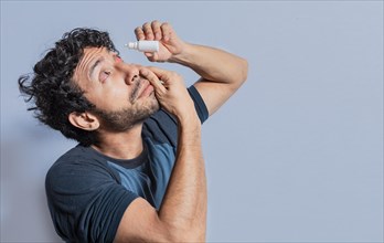 Person applying dropper to irritated eye. People applying refreshing drops to irritated eye. Man putting a dropper in his eye isolated. Man with irritated eye applying drops with a dropper