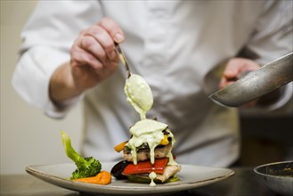 Chef pouring sauce meal