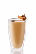 Hot milk winter drink with cinnamon and anise in double wall glass