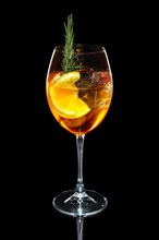 Cold Apple and orange cocktail with a sparkling wine with ice in wine glass isolated on black