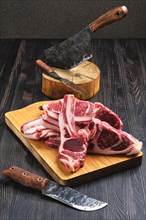 Raw lamb rib chops on wooden cutting board