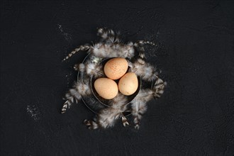 Three guinea fowl eggs in metal bowl