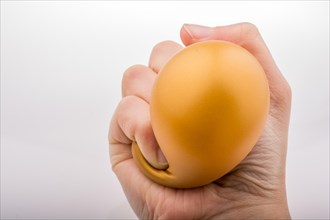 Squeezing yellow balloon with hand on a white background