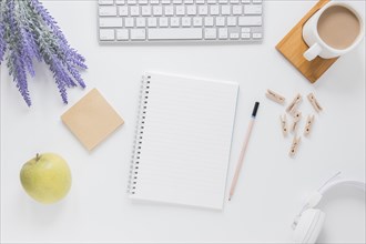 Opened notebook near stationery white table with gadgets coffee cup