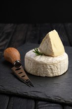 Brie cheese or camembert on stone board with knife for soft cheese