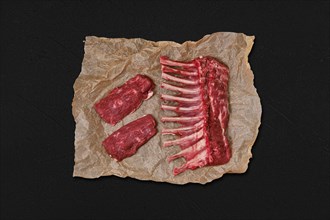 Overhead view of raw fresh rack of lamb and steak in wrapping paper