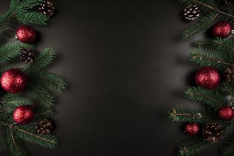 Christmas composition of green fir tree branches with red baubles