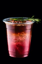 Espresso tonic with cherry juice in take away cup isolated on black background