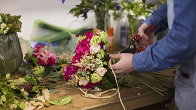 Close up male florist creating flower bouquet flower shop