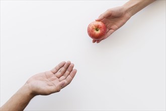 Hand giving apple needy person