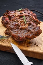 Grilled lamb neck on wooden cutting board