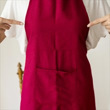 Midsection view woman pointing finger red apron