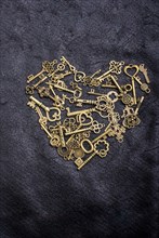 Retro style metal keys form a heart shape on black