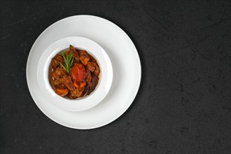 Overhead view of lamb stew with tomato on a plate