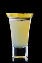 Shot with vodka and lemon juice isolated on black background