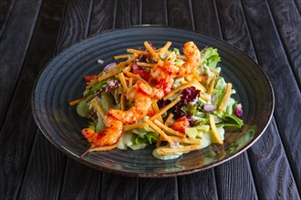 Shrimps on skewer with salad